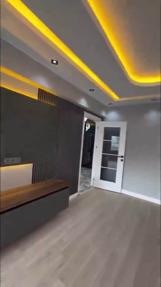Living room remodelled by our crew, with a television unit, slatted panelling and indirect LED lighting